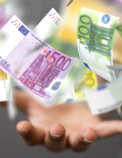 A closeup shot of a person presenting a euro rain with different bills